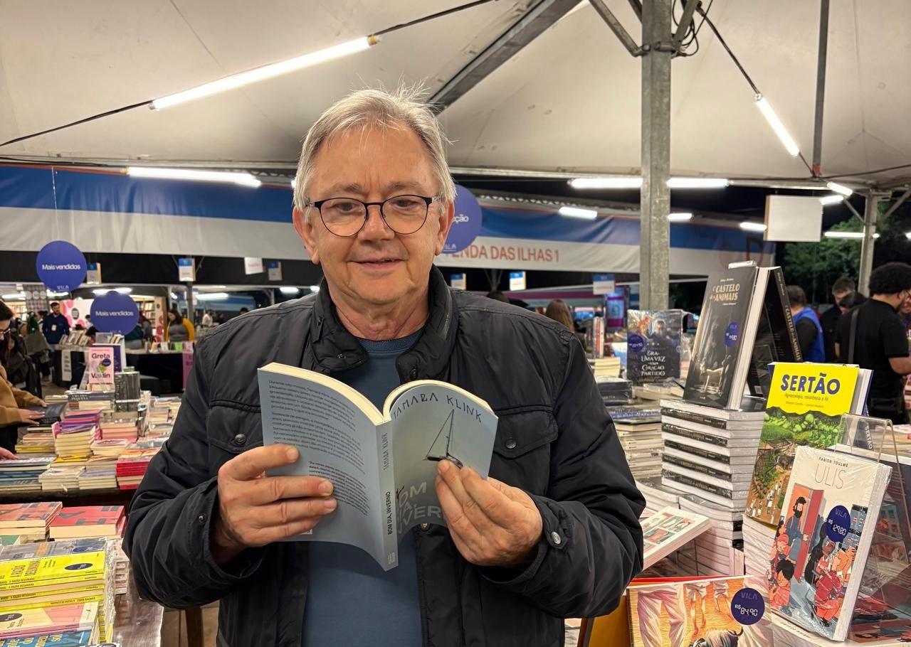 Tarcisio Miguel Sevegnani lendo um livro numa feira literária