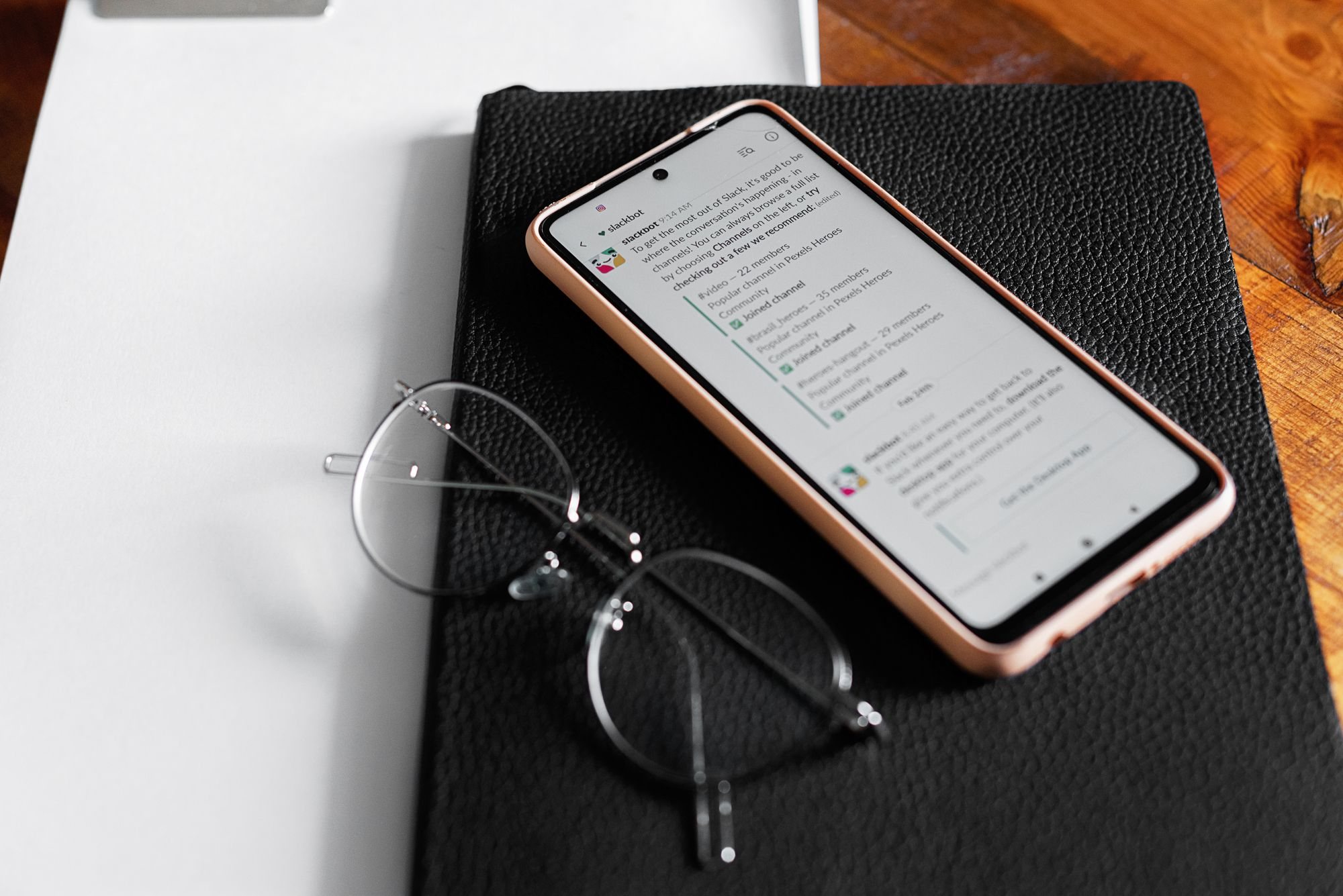 Celular aberto numa mensagem, ao lado de óculos de leitura